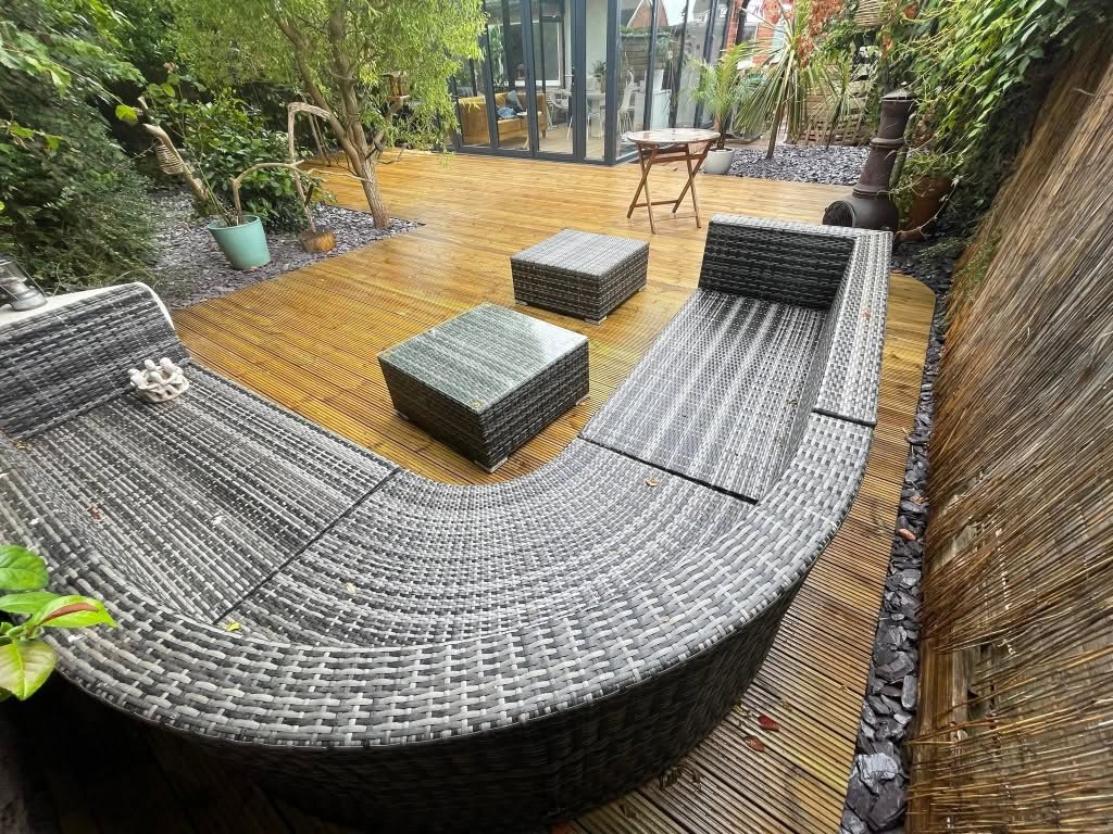 Timber deck with a rattan corner sofa and bamboo screening